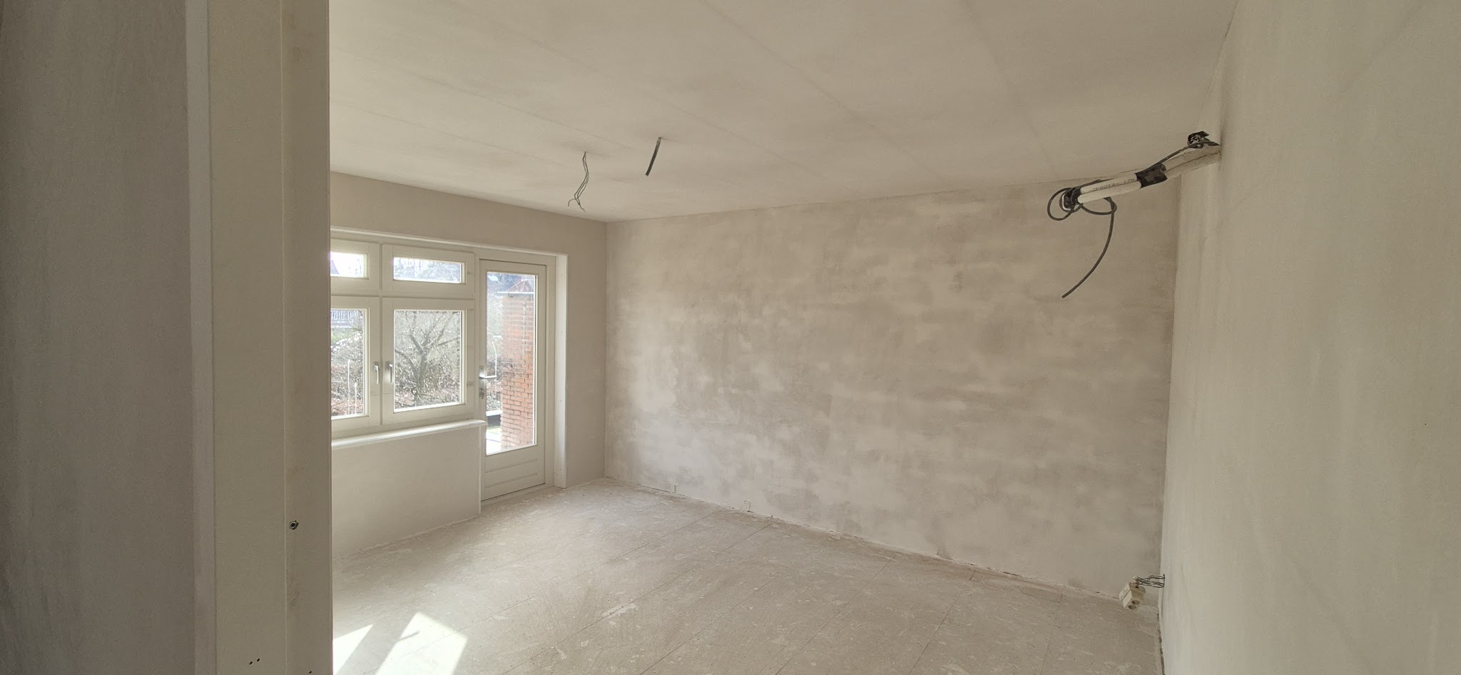 Lege kamer met vers gestucte wanden en plafond